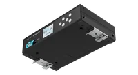 灰色的 S-PLAY SP1-1 底面，倾斜展示横向用螺丝固定的两根黑色安装条，每根都带有一个弹簧金属 DIN 导轨卡扣，左侧可见前面板及其显示屏。