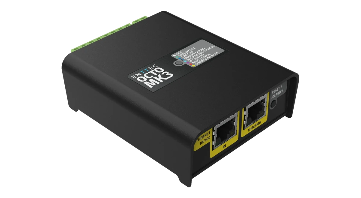 OCTO MK3 斜俯视图，顶盖印有“ENTTEC OCTO MK3”，旁边是灰色 LED 图例；近侧面为黄色 ETHERNET 10/100 IN 和 THROUGH 插座以及 RESET / IDENTIFY 按钮，远侧边缘为绿色端子。