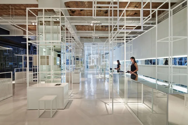 店内场景,一位顾客站在点亮的玻璃展柜前,上方是白色钢结构框架与外露的木质天花