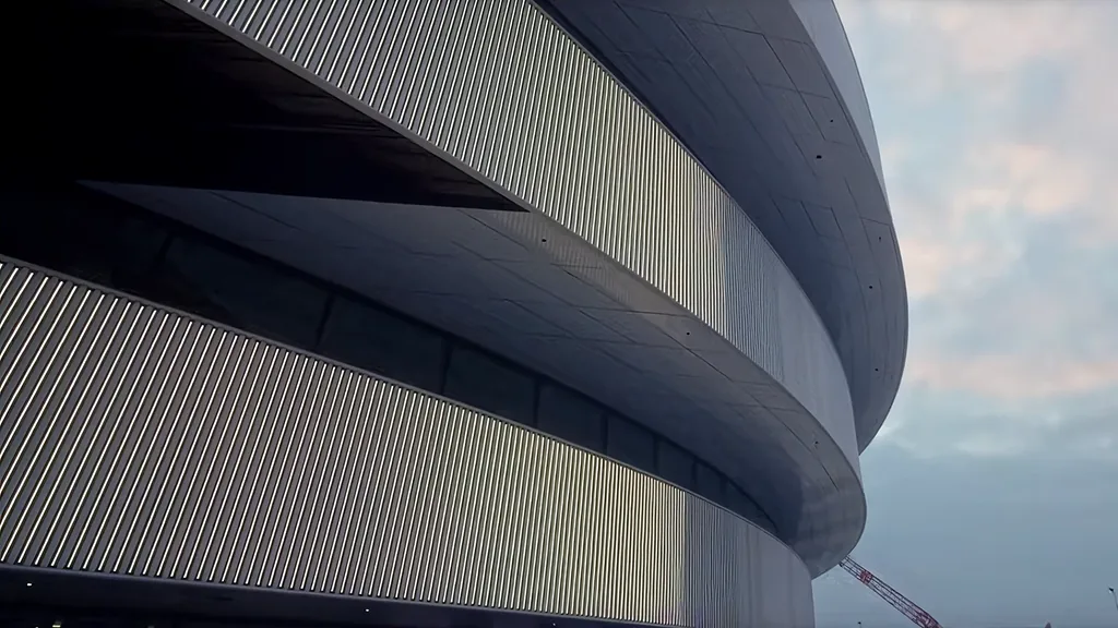 The layered aluminium rings of the arena against the dusk sky