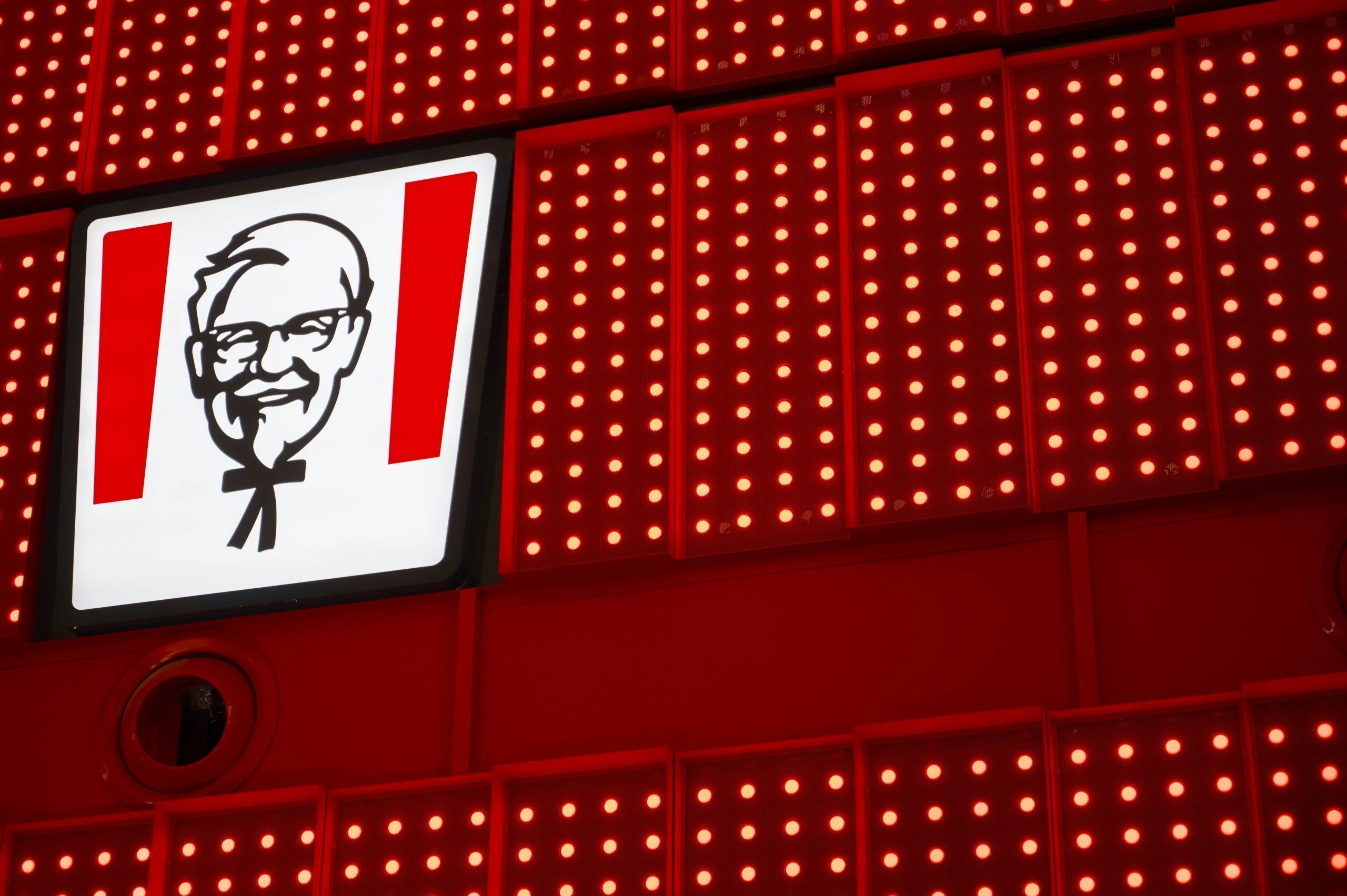 Colonel Sanders 标识面板的正面特写，四周被红色像素点面板填满